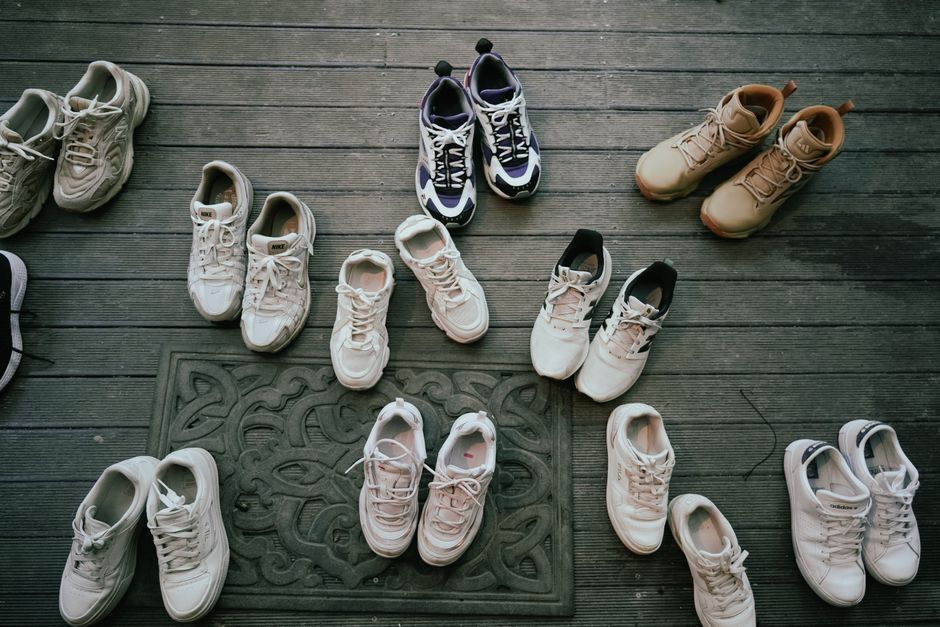 Various pairs of sneakers neatly laid out on a wooden deck, showcasing different styles.